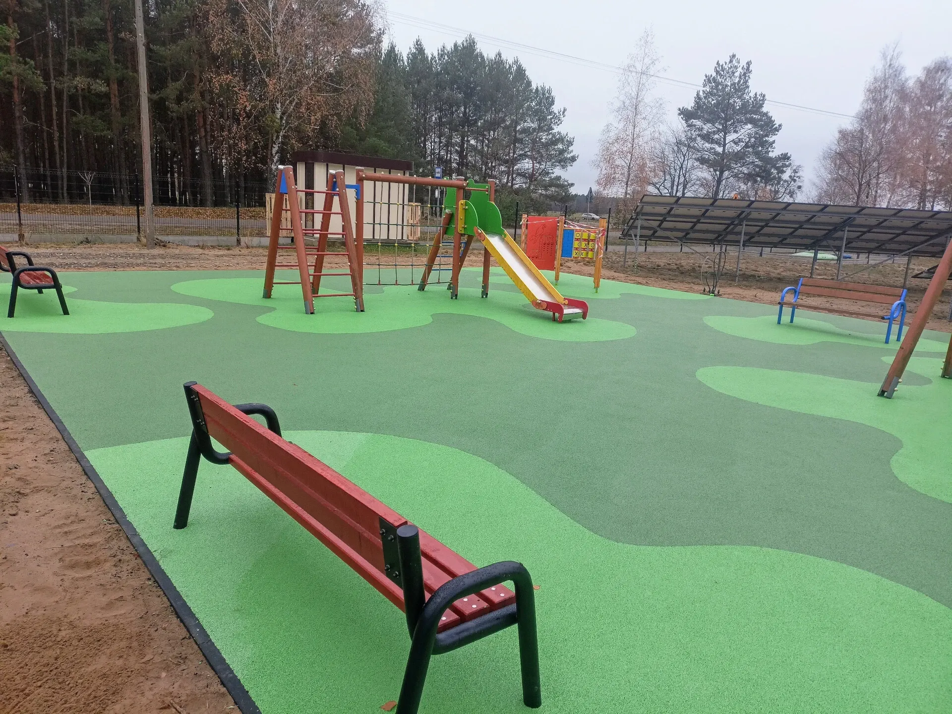 Zielona nawierzchnia EPDM na placu zabaw z urządzeniami