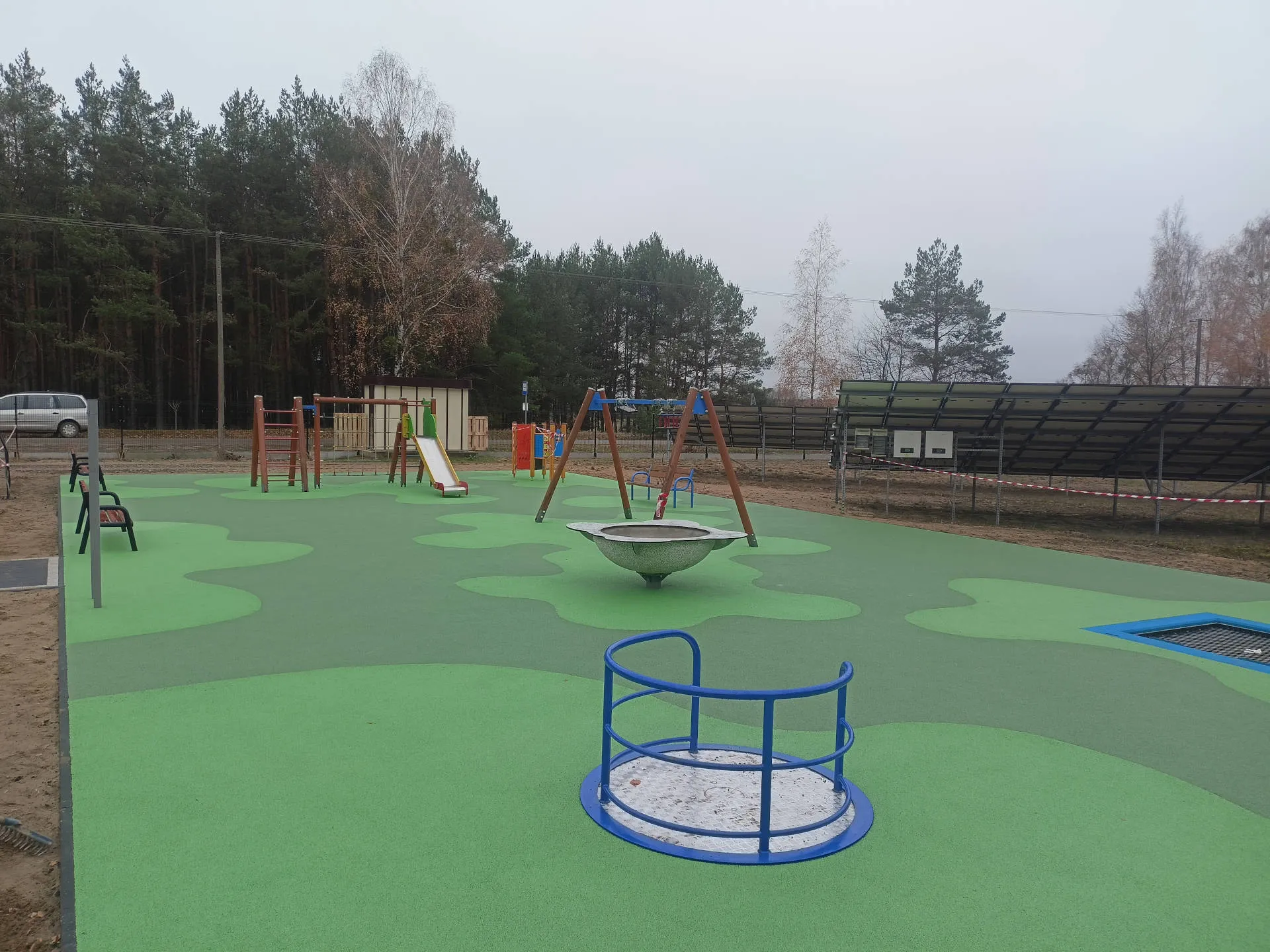 Rozległy plac zabaw z urządzeniami i bezpieczną nawierzchnią